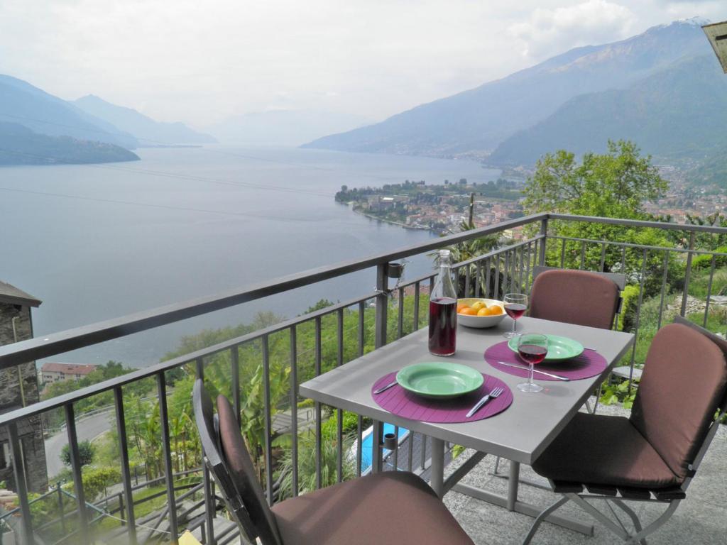 a table and chairs on a balcony with a view of a lake at Barolo in Gravedona