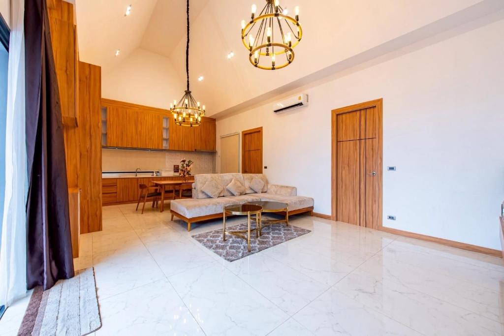 a living room with a couch and a table at TheH Pool Villa in Nong Prue