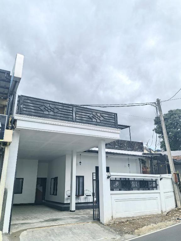 a white building with a balcony and a garage at Pierdi Villa in Panundaan