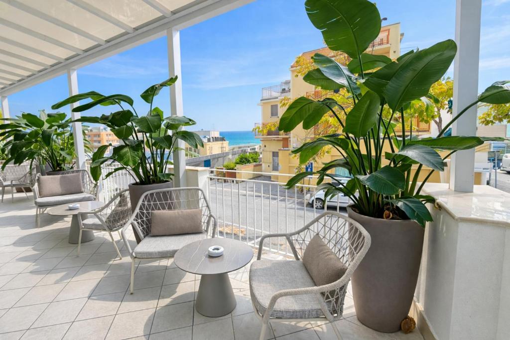 a balcony with chairs and plants and a view of the ocean at Hotel Regal in Rimini