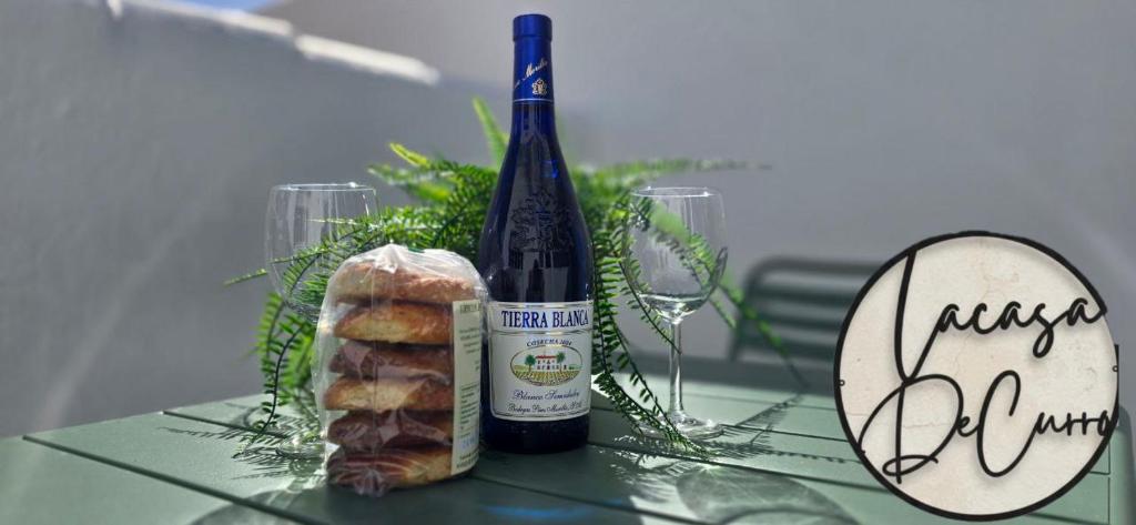 a bottle of wine and a piece of bread on a table at La casa de curro in Arcos de la Frontera