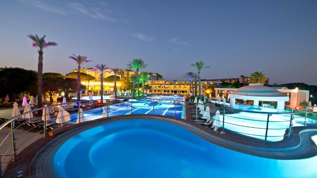 a view of a pool at a resort at night at Limak Atlantis Deluxe Hotel Belek in Belek