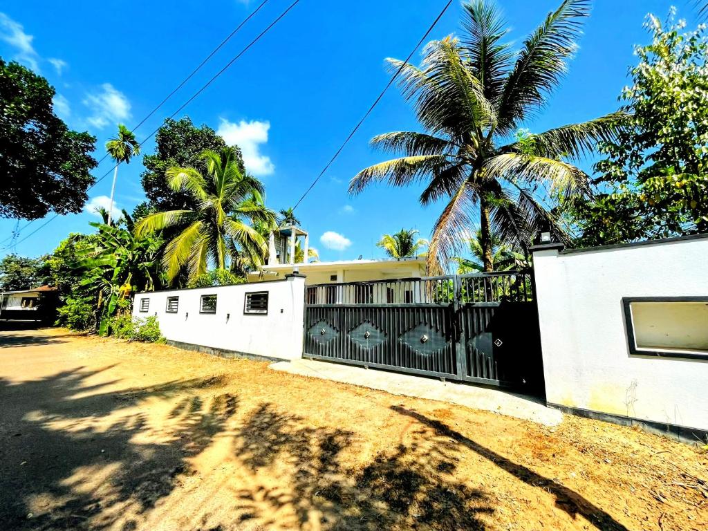 a house on a dirt road with palm trees at Lotus villa in Matara