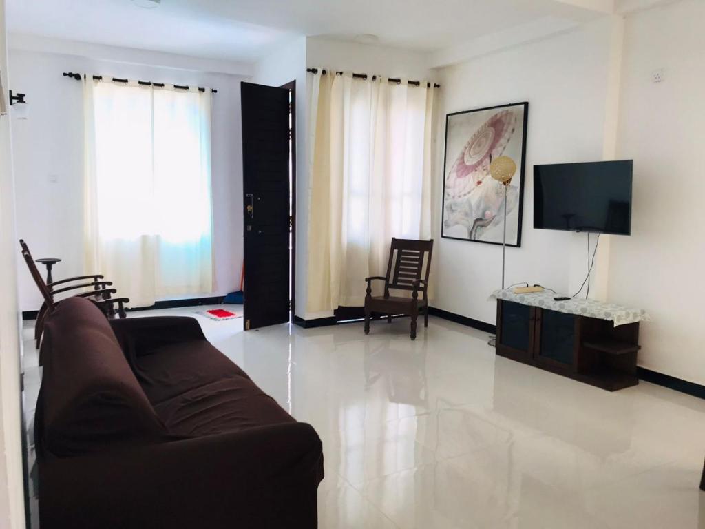 a living room with a couch and a tv at Marissa Villa in Katunayaka