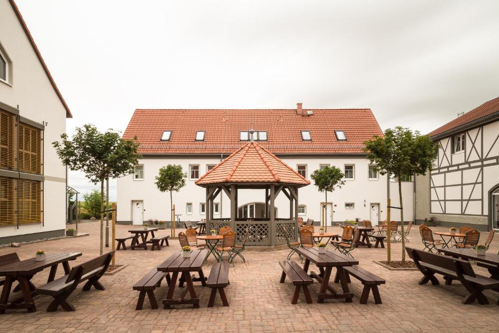 einen Pavillon mit Holztischen und Bänken im Innenhof in der Unterkunft Landhotel Sonnenhof in Ossig