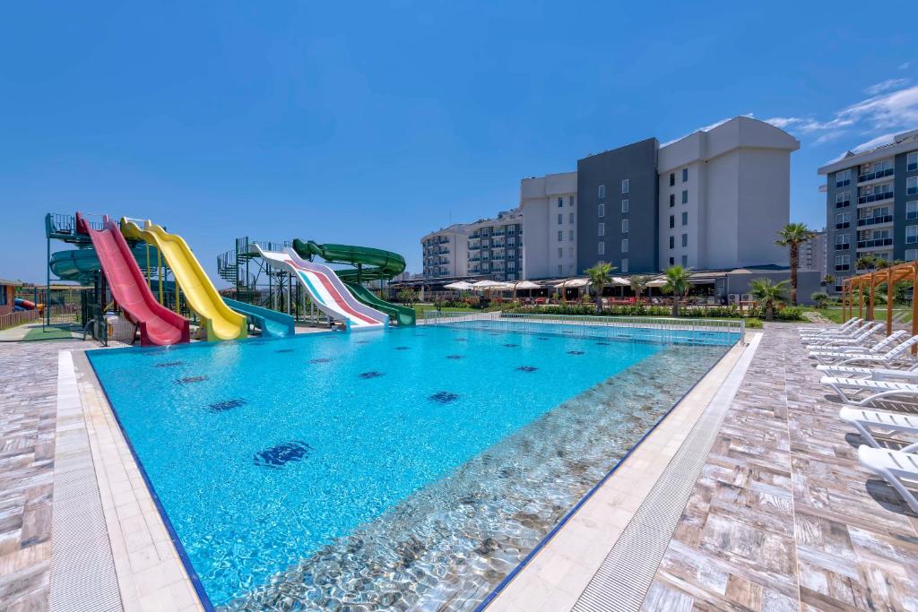 a pool at a resort with a water slide at Palmora Lara Hotel in Aksu