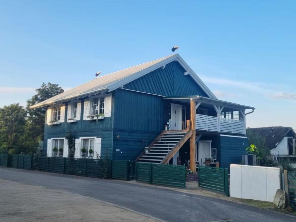 a blue house with a porch and a staircase at Ferienwohnung Das grüne Haus in Byhlen