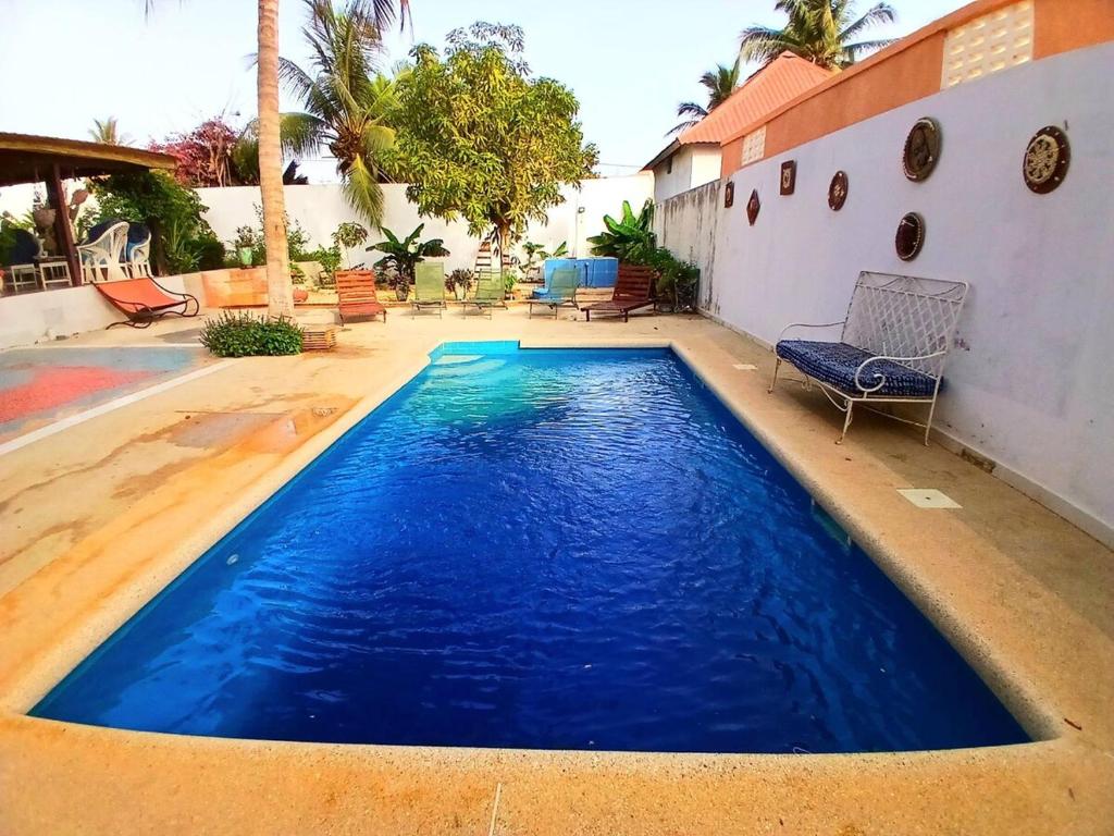a pool with blue water in a yard at Cozy Studio with Private Jacuzzi and Pool! in Saly Portudal