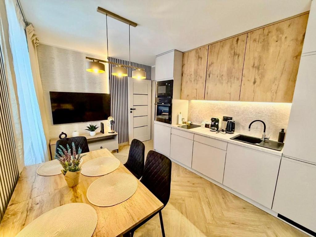 a kitchen and dining room with a table and chairs at Fly Apartment Modlin by JumpInHere in Nowy Dwór Mazowiecki