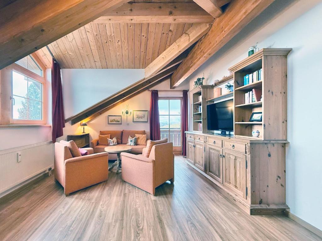 a living room with two chairs and a couch and a tv at Sonnenhof Seeg 14 in Seeg