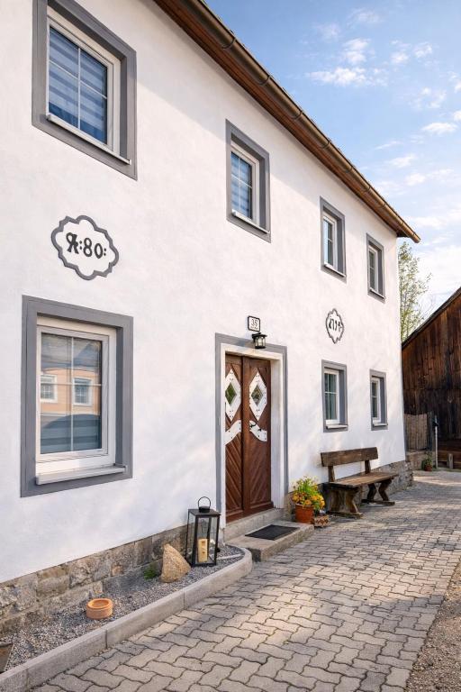 a white building with a brown door and a bench at Haus Erna Weitra in Weitra