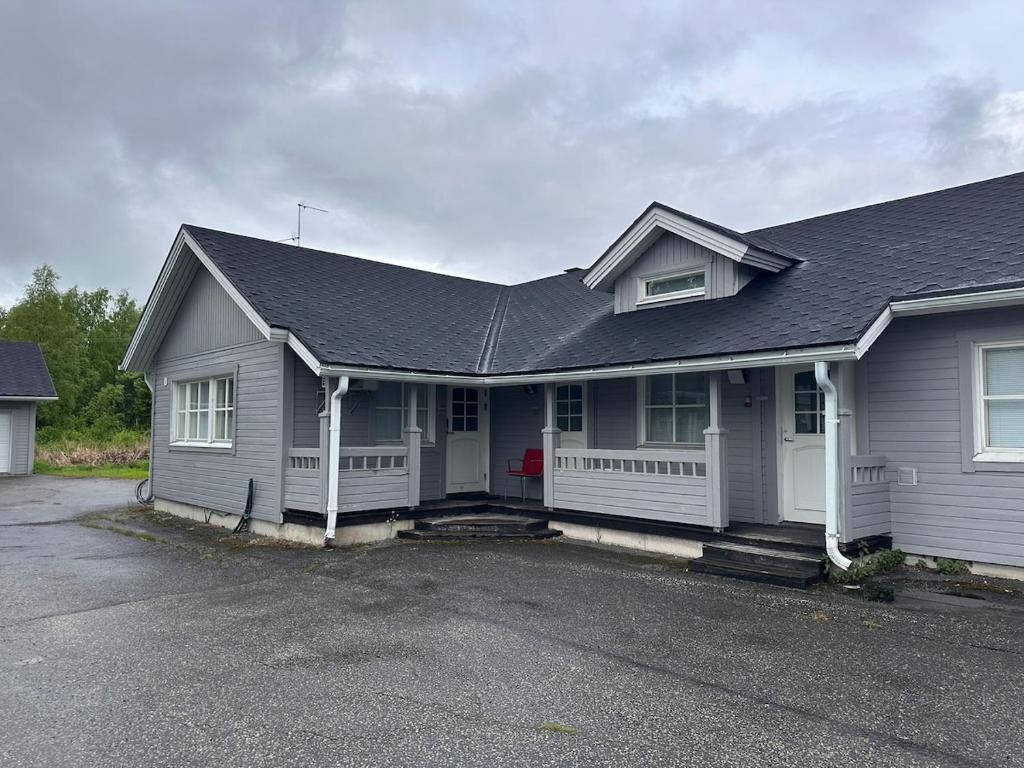 a white house with a black roof at Affordable, fully equipped practical housing! in Laivaniemi