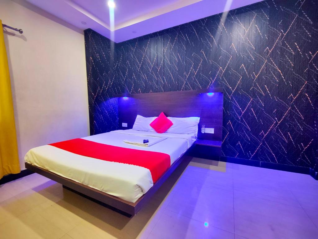 a bedroom with a large bed with a red pillow at Jubilee Homes in Hyderabad