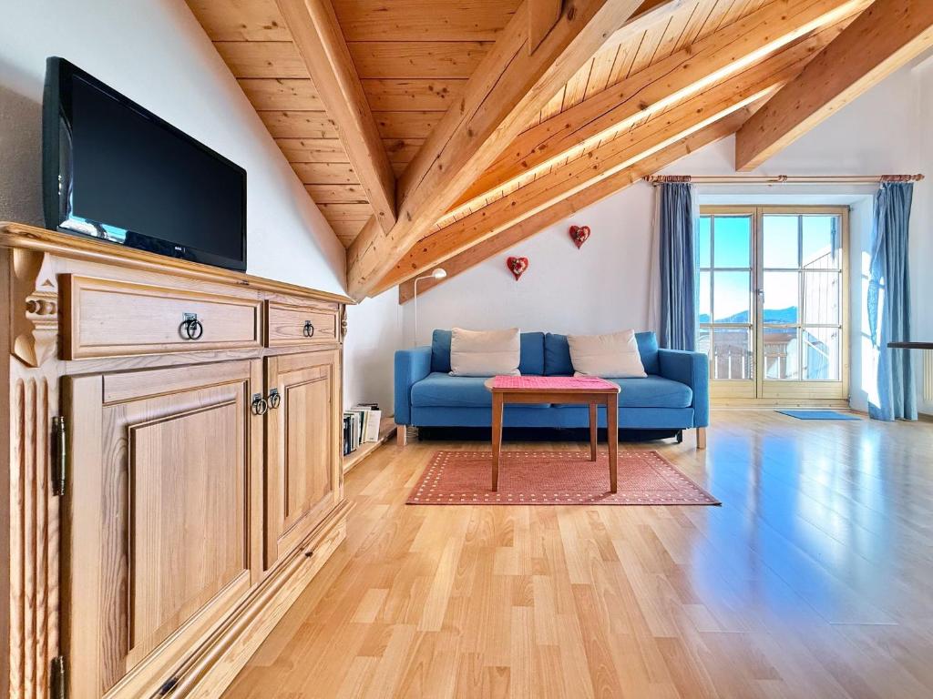 a living room with a blue couch and a red stool at Sonnenhof Seeg 17 in Seeg
