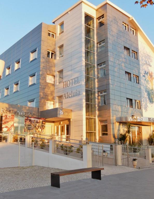 a hotel building with a bench in front of it at Hotel Aleluia in Fátima