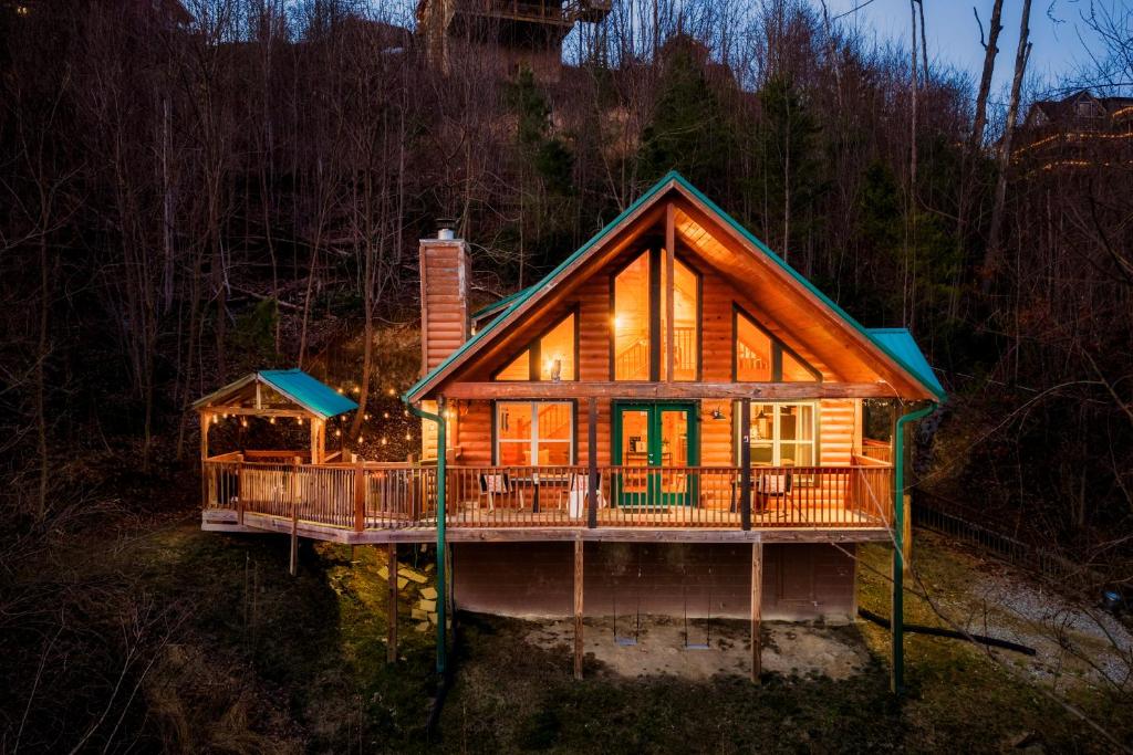 a cabin in the woods with a wrap around deck at Take It Easy - 5 Star Family Cabin View Hot Tub FirePit Pools Bears in Gatlinburg