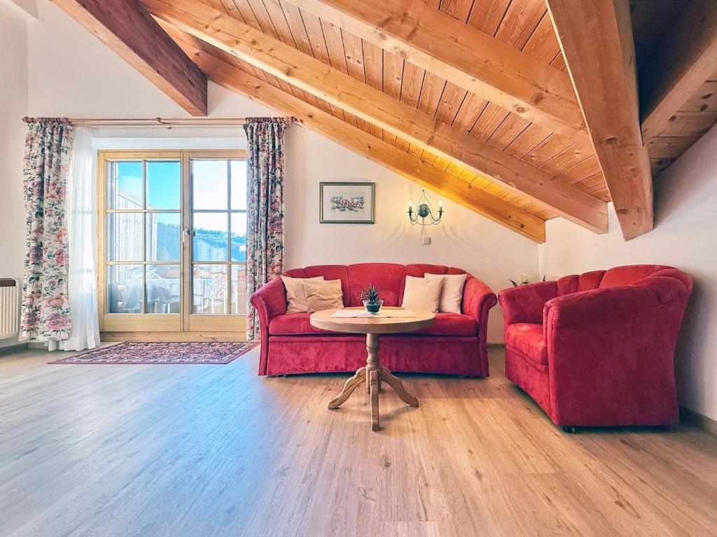 a living room with a red couch and a table at Sonnenhof Seeg 16 in Seeg