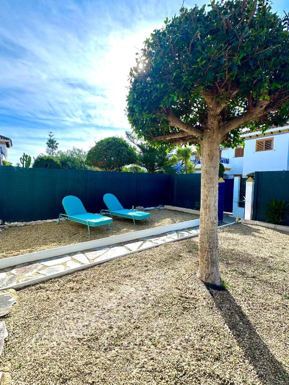 two blue chairs and a tree in a yard at vera home shine in Vera