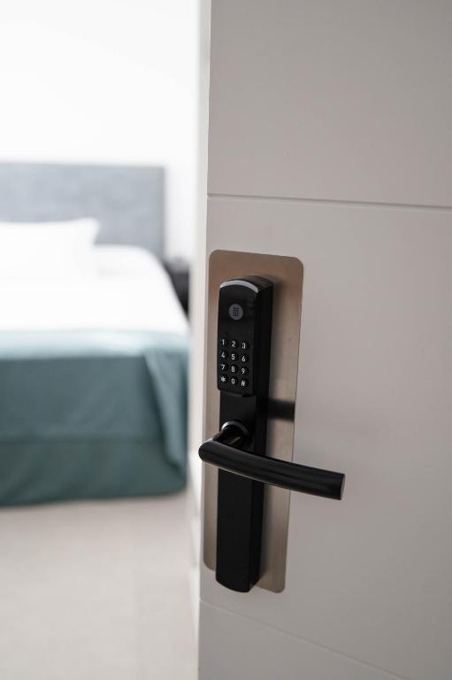 a door with a phone in a room with a bed at M&A Hostal en Onda in Bechí