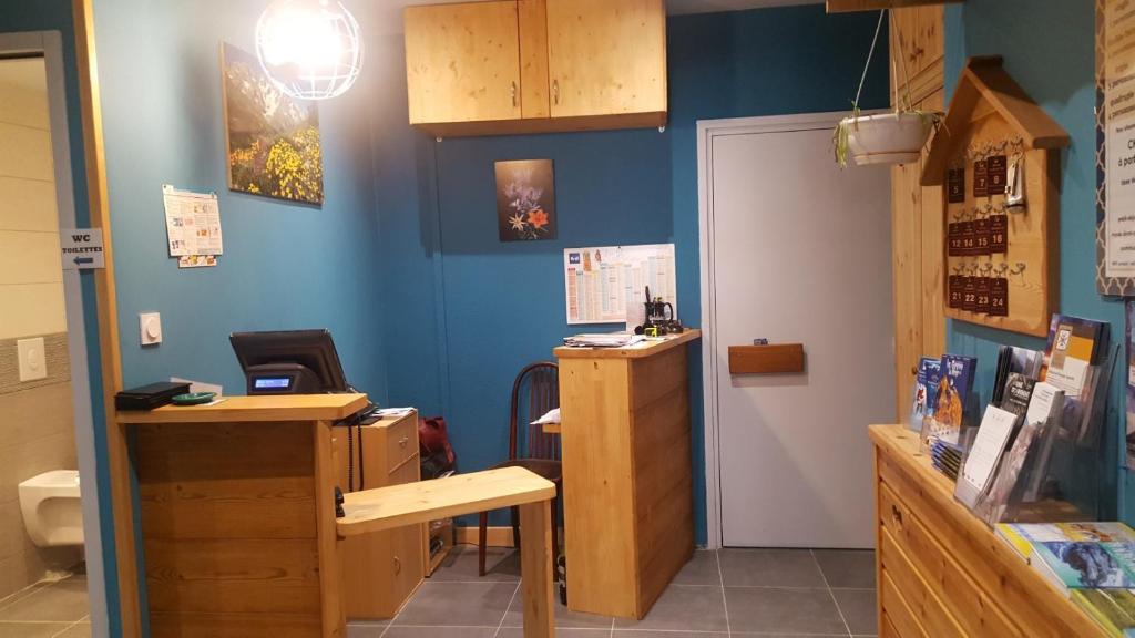 a room with a blue wall and a desk at Hotel Glaizette in LʼArgentière-la-Bessée