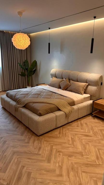 a large bed in a bedroom with a wooden floor at Grandstay in Al Hofuf