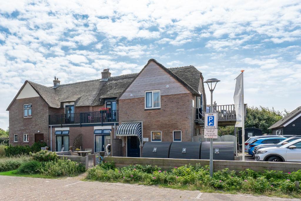 a large brick house on a street with a parking lot at Appartementen Parkzicht in Bergen aan Zee