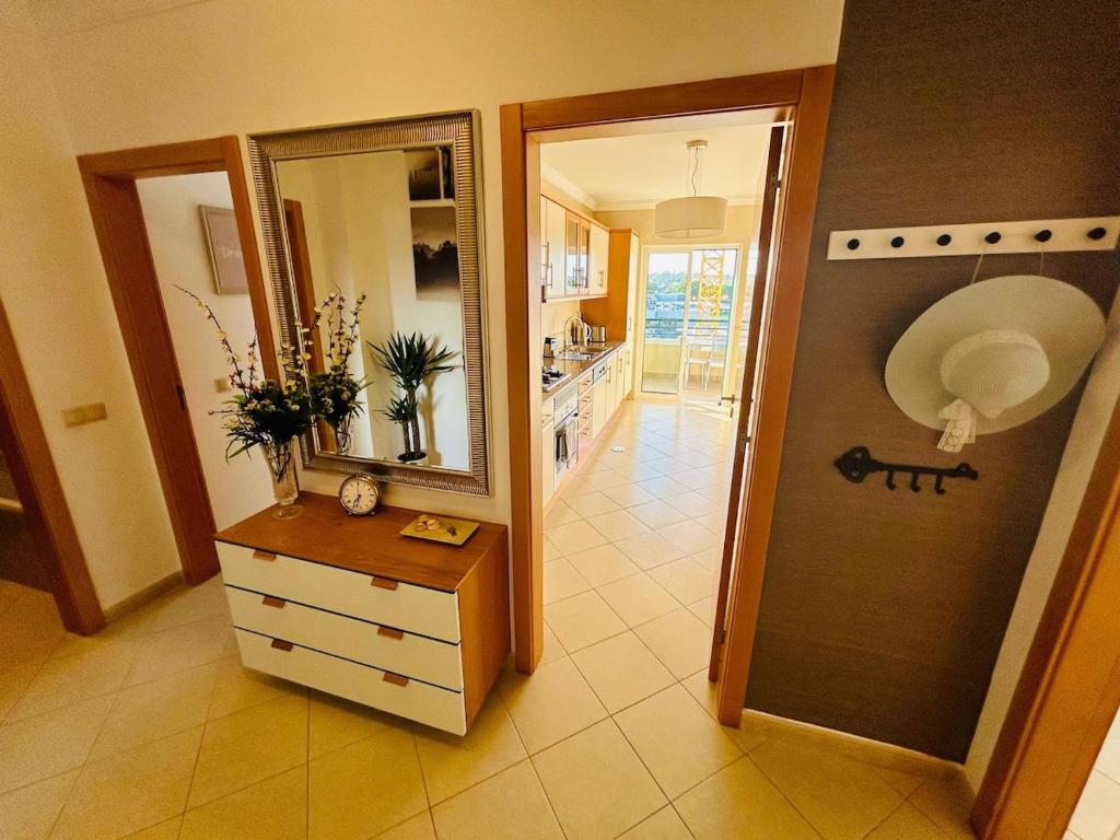 a kitchen with a dresser and a large mirror at The Seashell Armação Beach Apartment in Armação de Pêra