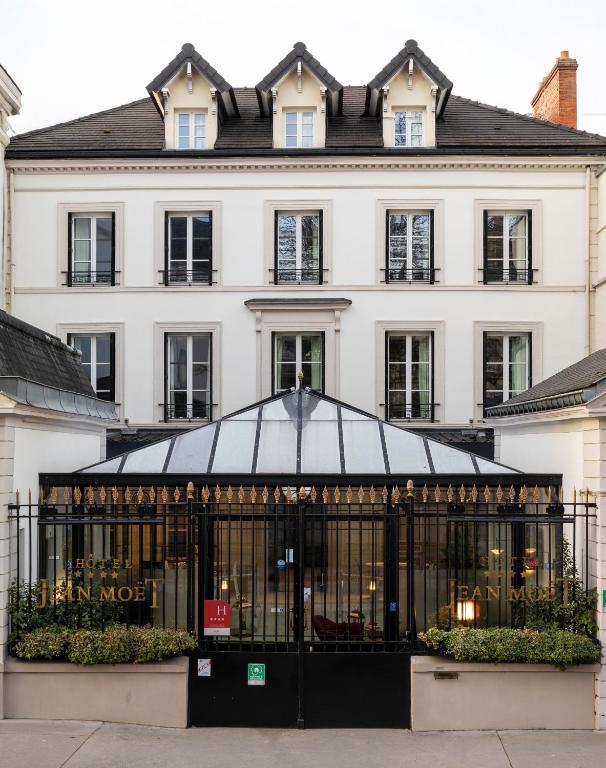 a large white building with a black at Hotel Jean Moët in Épernay