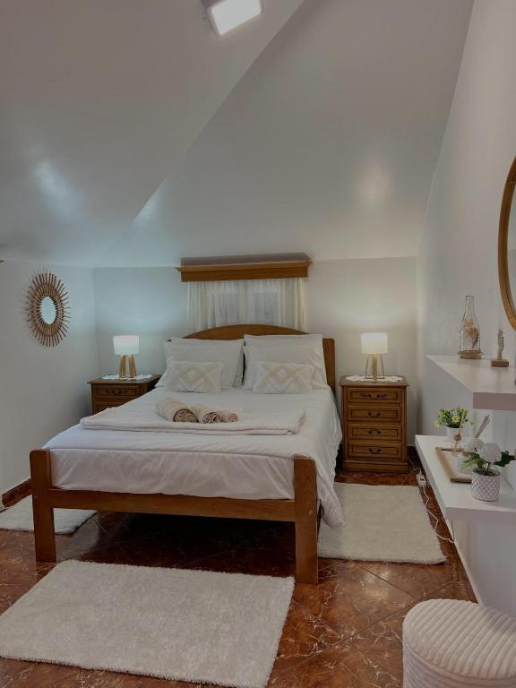 a bedroom with a bed and two tables and a mirror at Maria apartment in Ponta do Sol