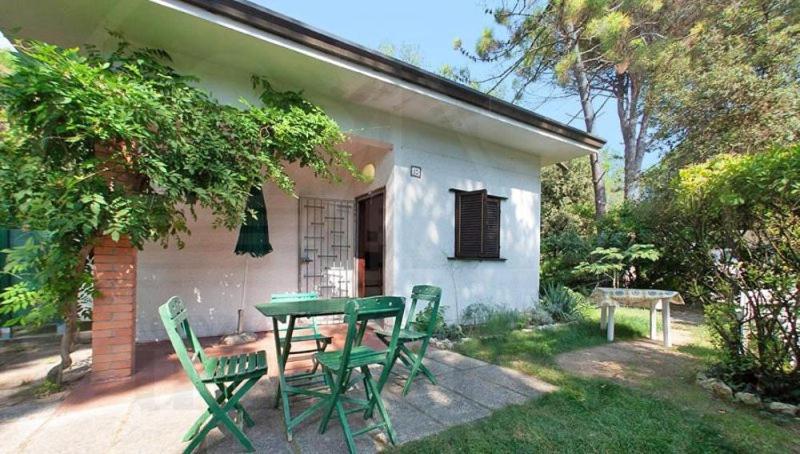 a picnic table and chairs in front of a house at Bungalow Baleno in Eraclea Mare