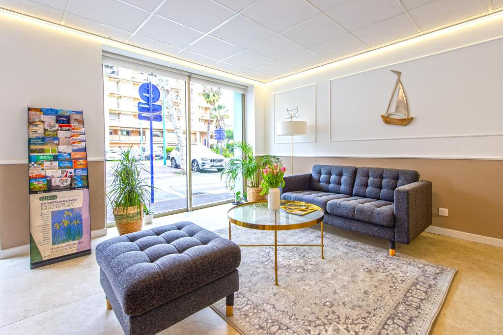 a living room with two couches and a table at Hotel Parisien in Menton