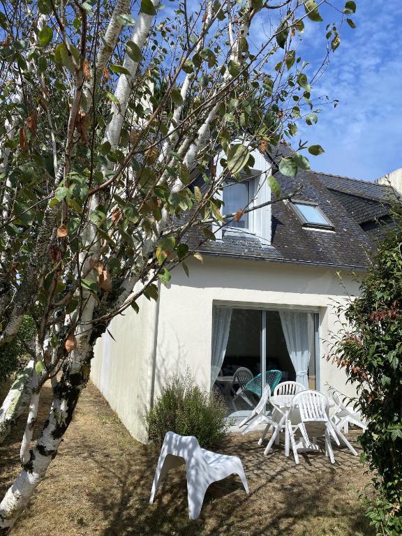 a white house with white chairs and a tree at KREISKER 4 - Maison Jumelée, Jardin - CA6010 in Carnac