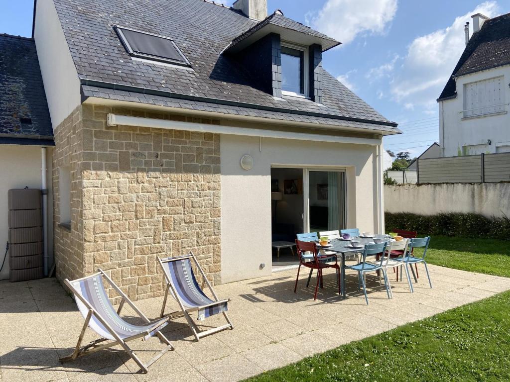 a patio with a table and chairs in front of a house at RIVAGE - Villa 6 pièces, Jardin, Calme - S28 in Carnac