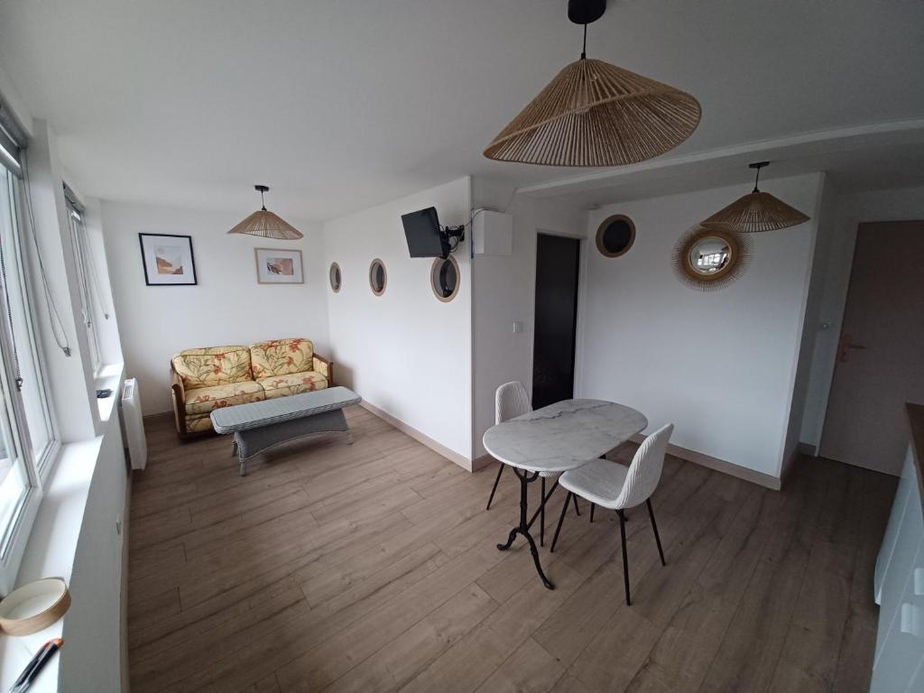 a living room with a table and a couch at Le bon accueil in Coucy