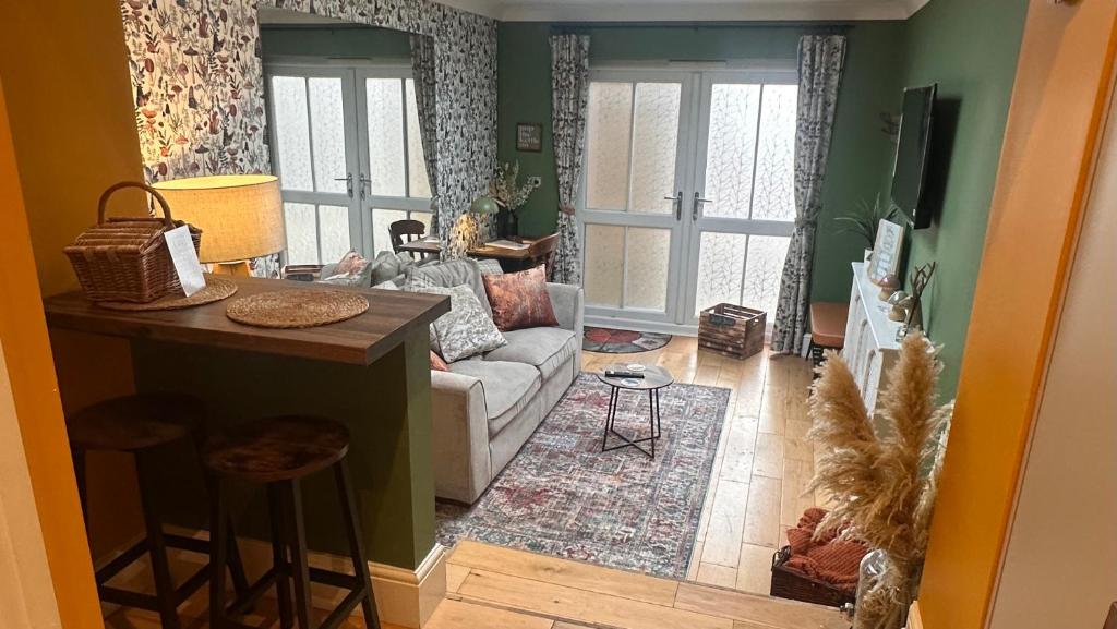 a living room with a couch and a table at Garden Galley Nook in Sproatley