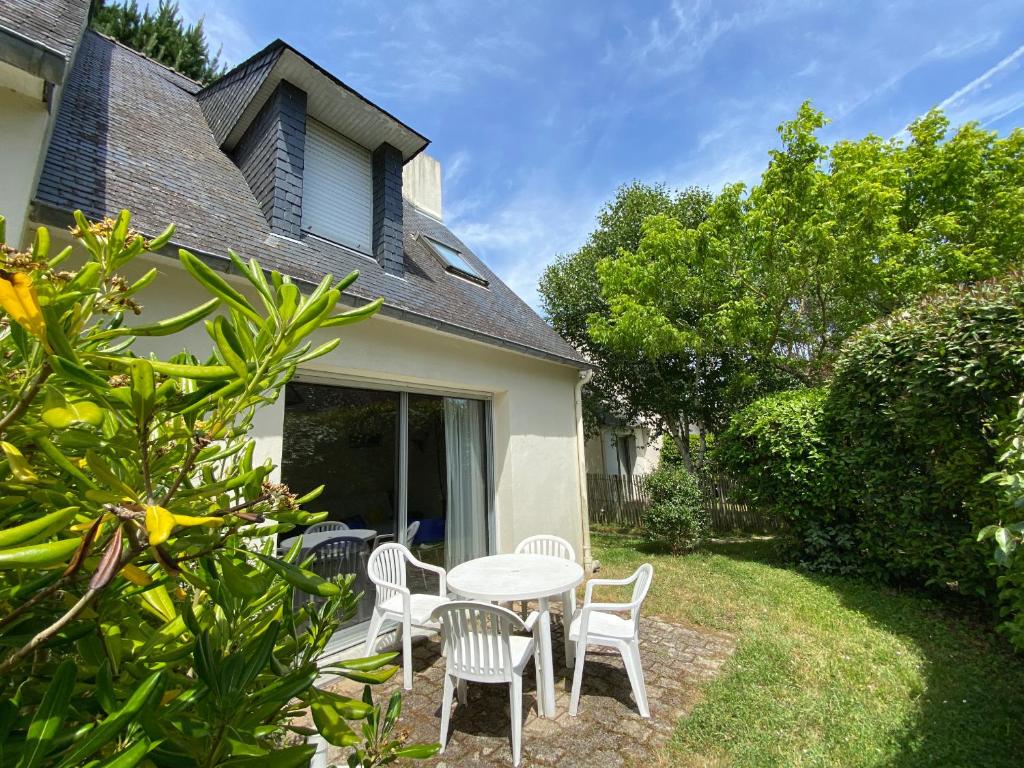 a patio with a table and chairs in front of a house at KREISKER 3 - Maison Jumelée, Jardin - CA6009 in Carnac