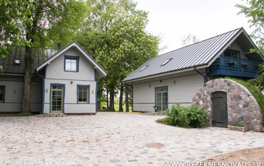 ein weißes Haus mit Garage und Einfahrt in der Unterkunft Stikāni in Bernāni