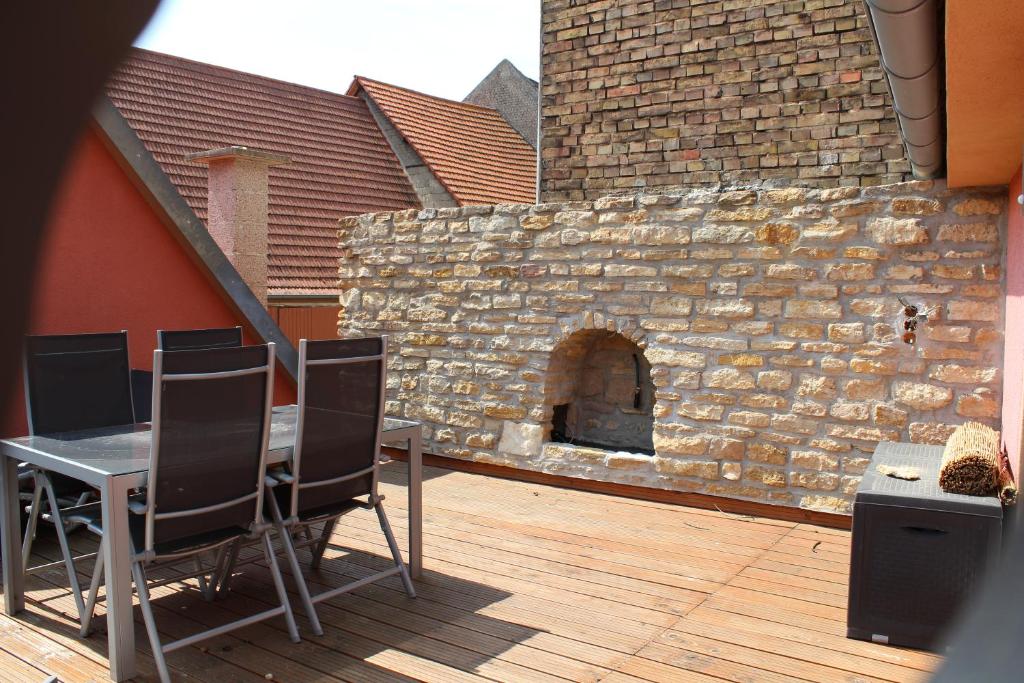 a patio with a table and chairs and a brick wall at Toscana1 in Freimersheim