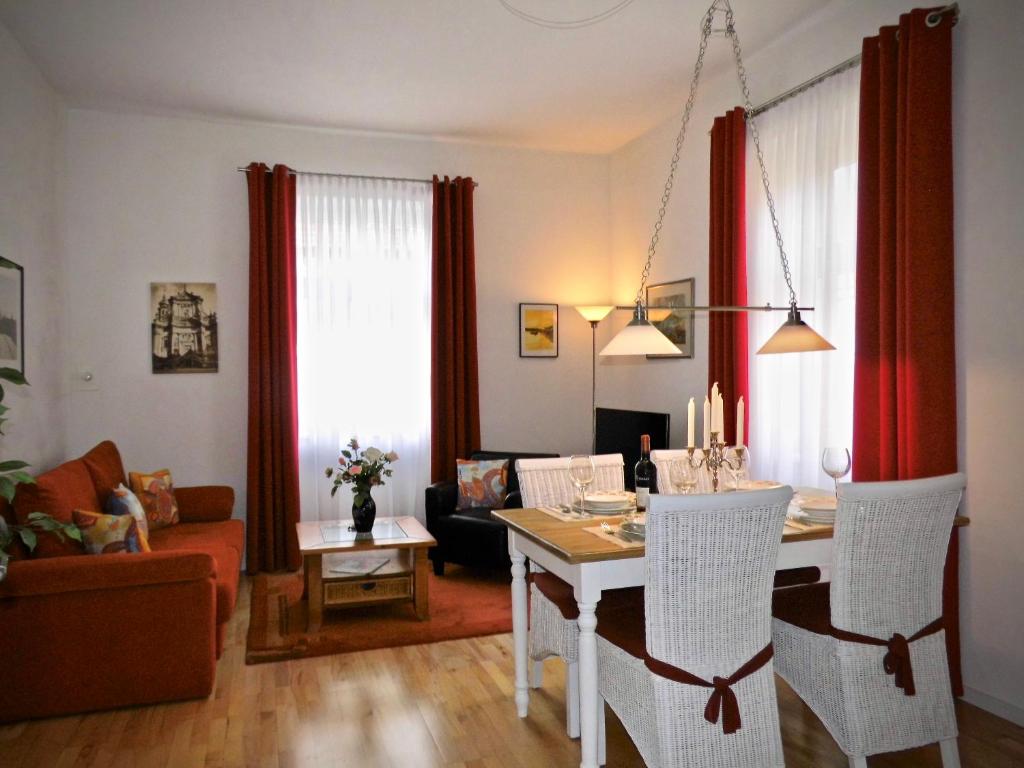 a dining room and living room with a table and chairs at Ihr Domizil auf Zeit in Würzburg in Würzburg