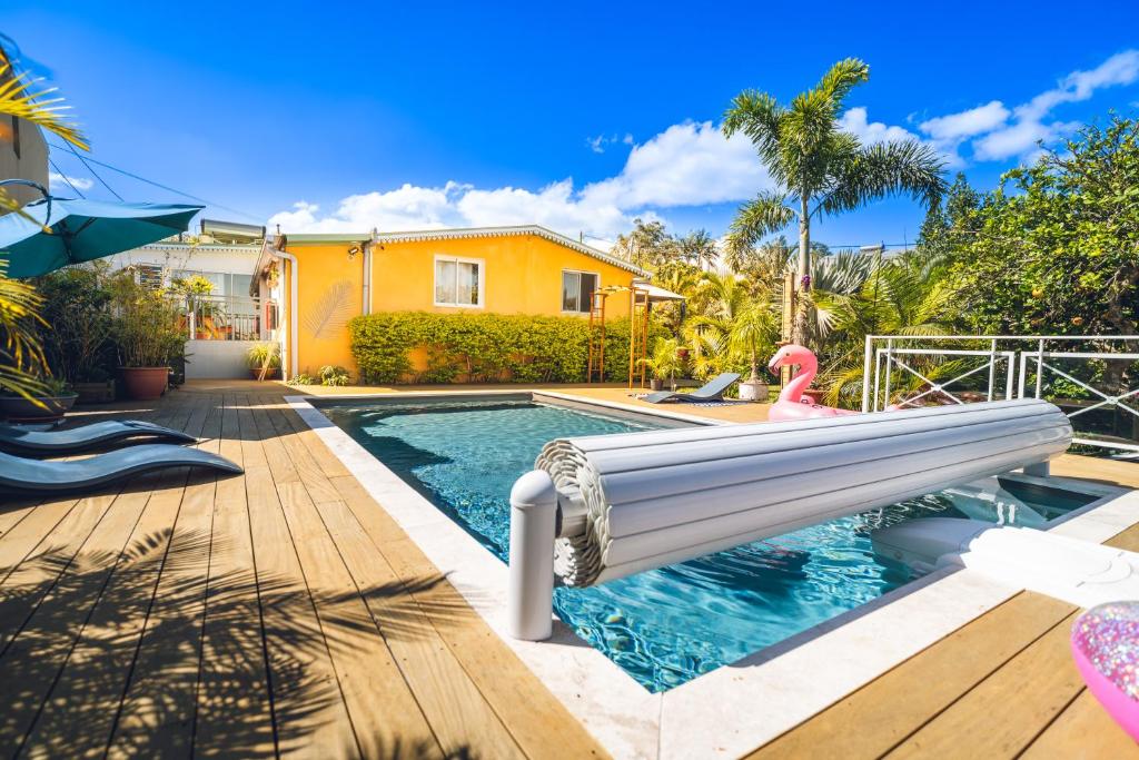 a pool with a water slide in a house at Le Palmier de la Paix in Le Tampon