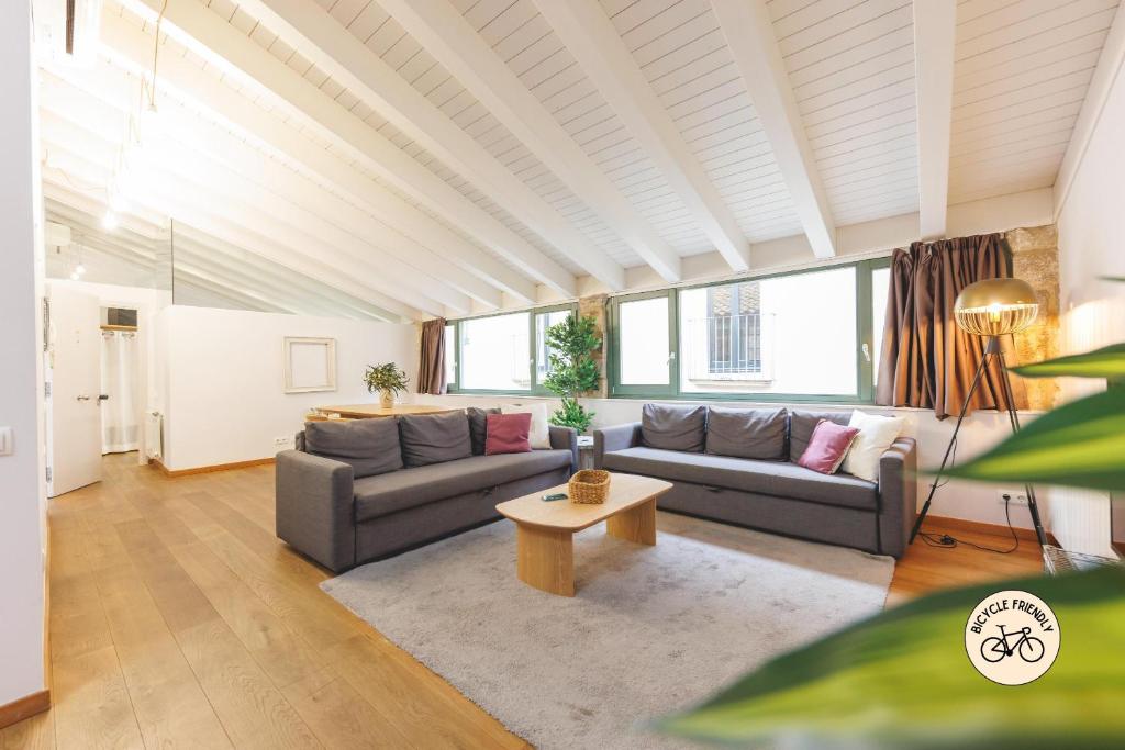 a living room with two couches and a table at Bravissimo Força 17, Barri Vell apartments in Girona