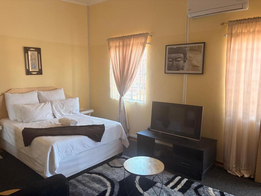 a bedroom with a bed and a flat screen tv at Philly-Wen Guesthouse in Schweizer-Reineke