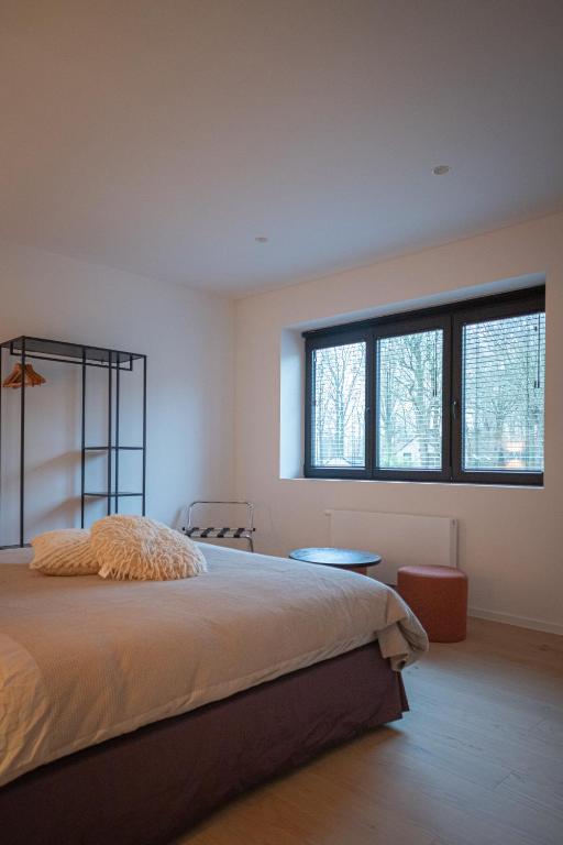 a bedroom with a large bed and two windows at Stories Lodewijk en Margaretha in Bruges