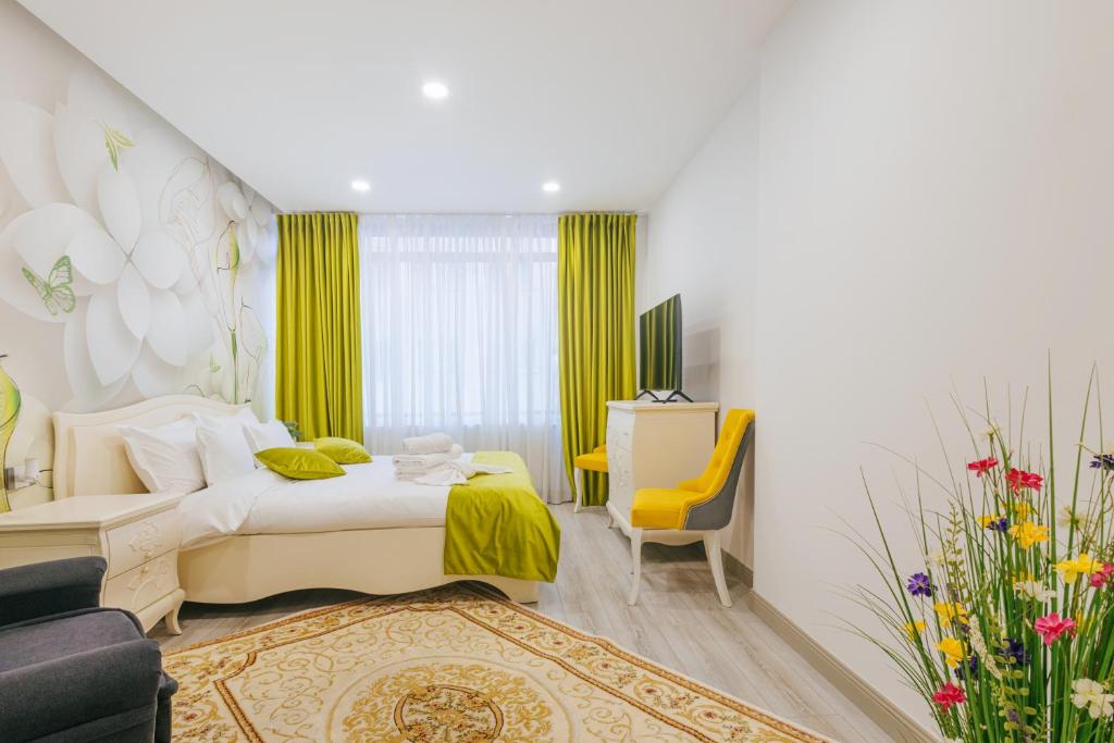 a bedroom with a bed and a yellow chair at Damone Residence in Gura Humorului