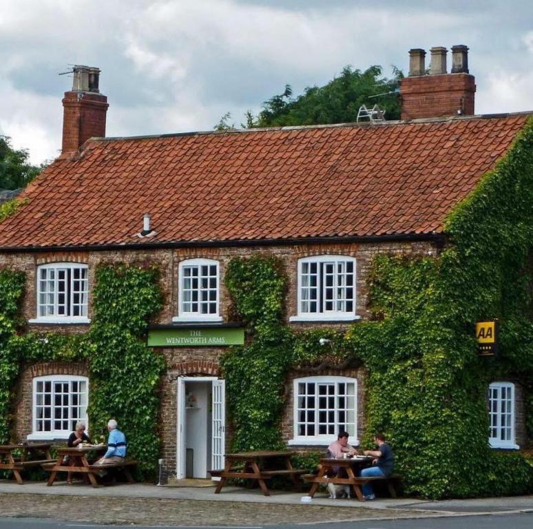people sitting at tables outside of a brick building at Wentworth arms in Malton