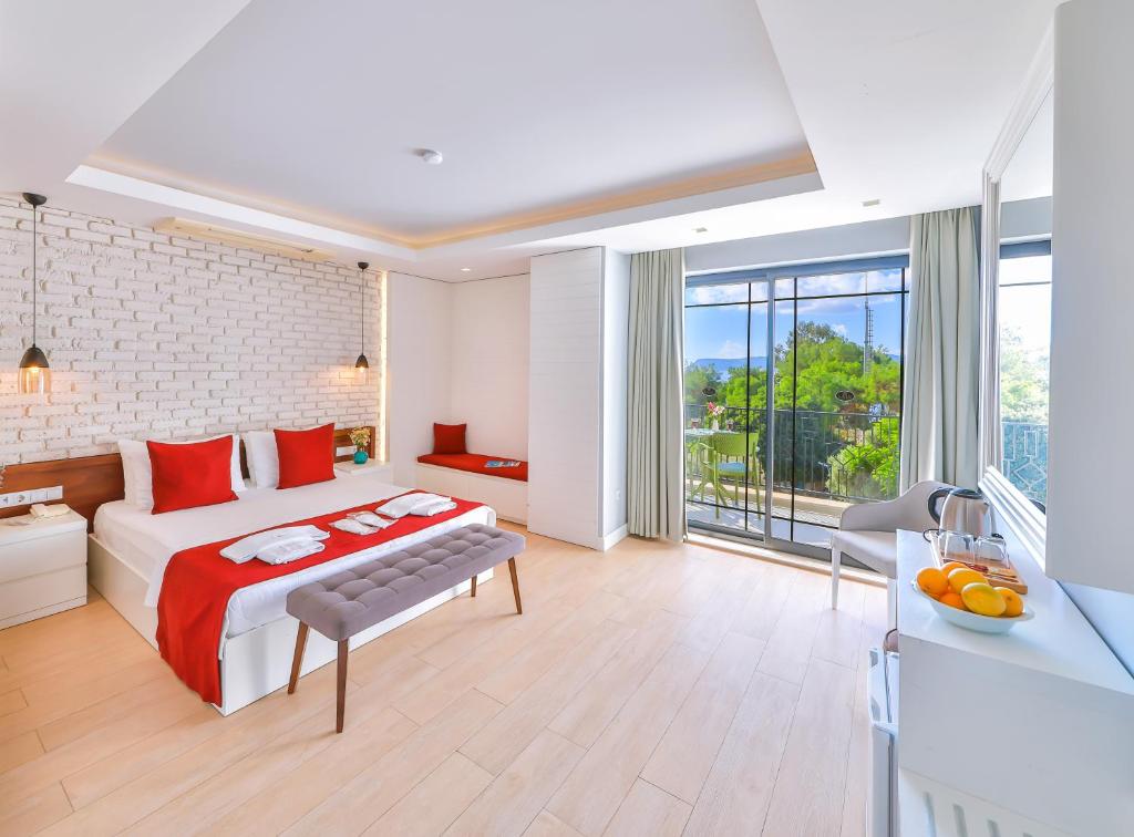a hotel room with a bed and a balcony at Lale Hotel in Kaş
