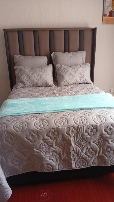 a bedroom with a large bed with white sheets and pillows at Epic touch B&B in Sandton