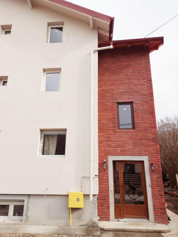a white building with a brown door at Srna apartmani in Čačak