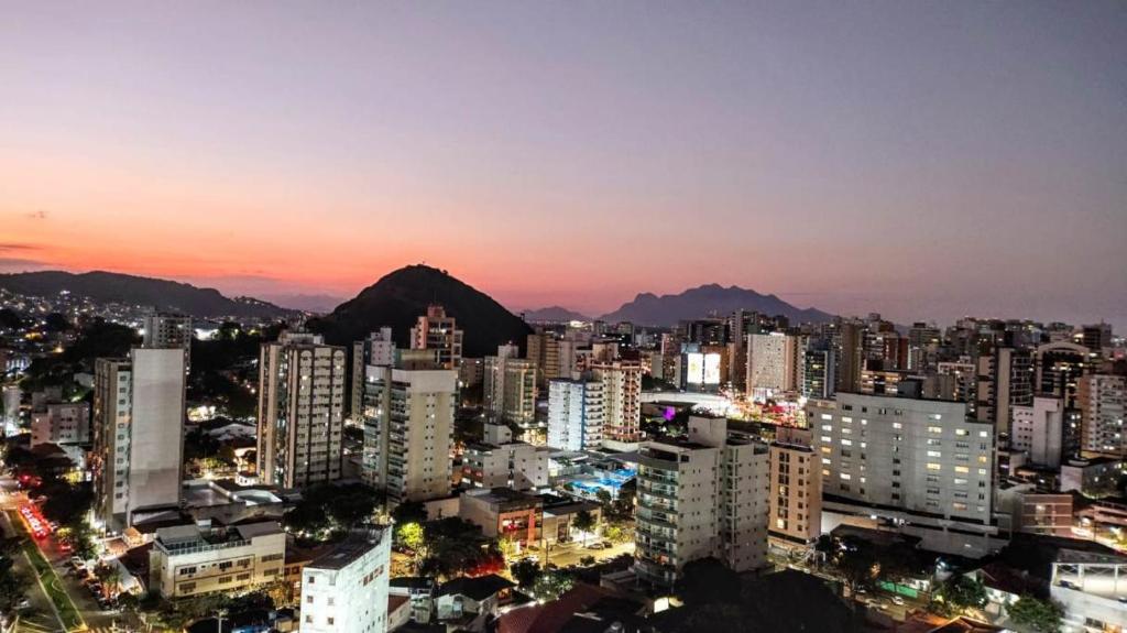 a city skyline at night with mountains in the background at Prince 1513 in Vitória