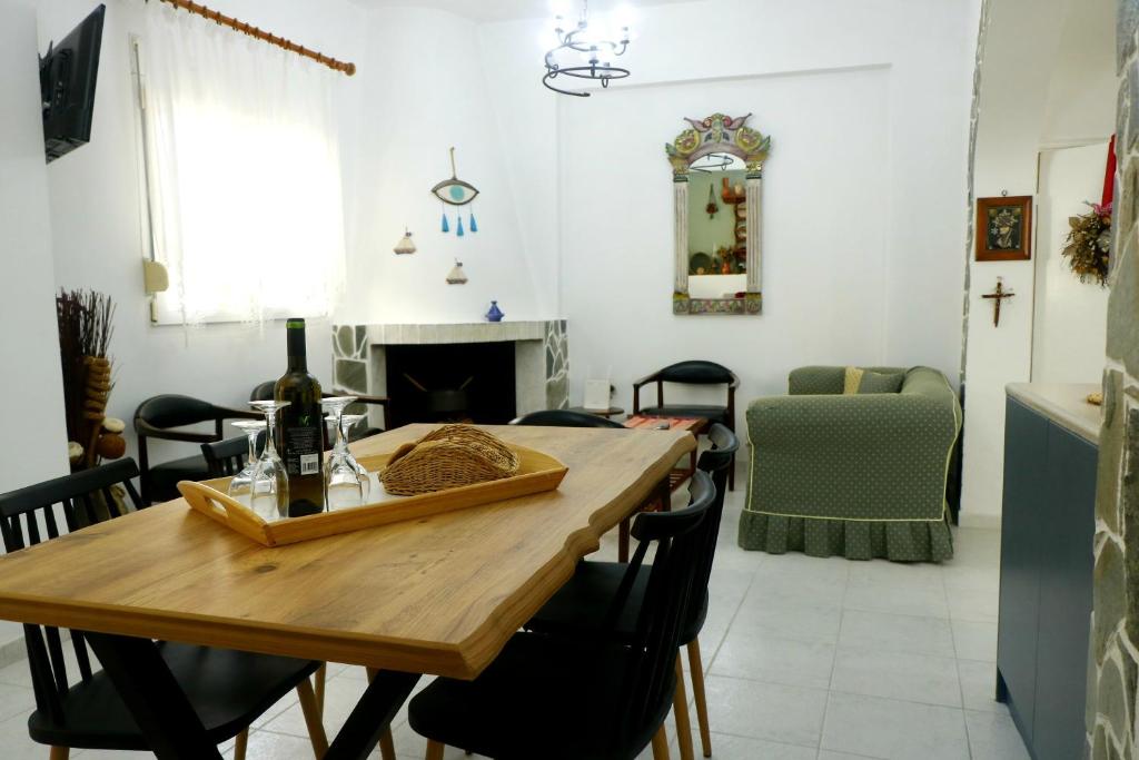 a dining room with a wooden table and a fireplace at Arco In Pietra in Apolakkiá